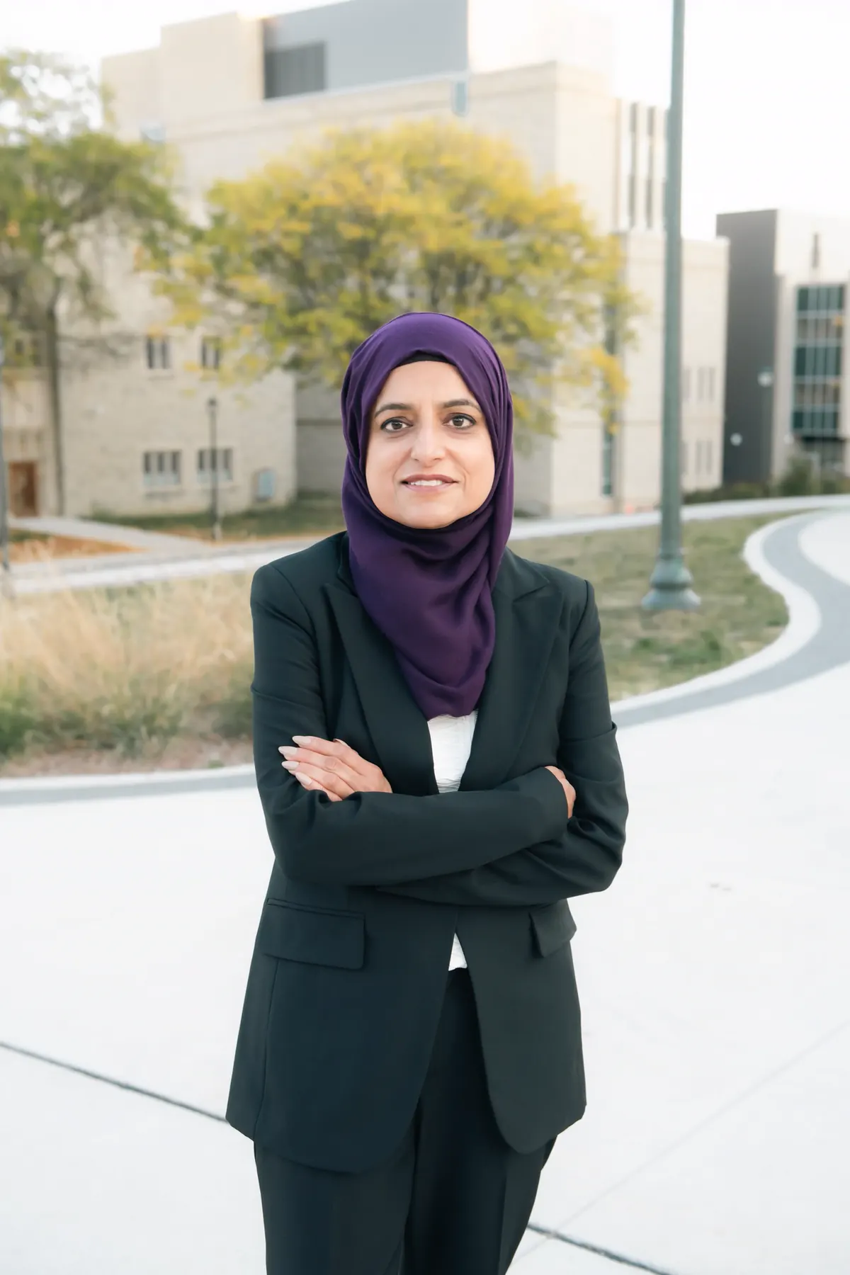 Najia Mahmud, family lawyer, standing outdoors with arms crossed
