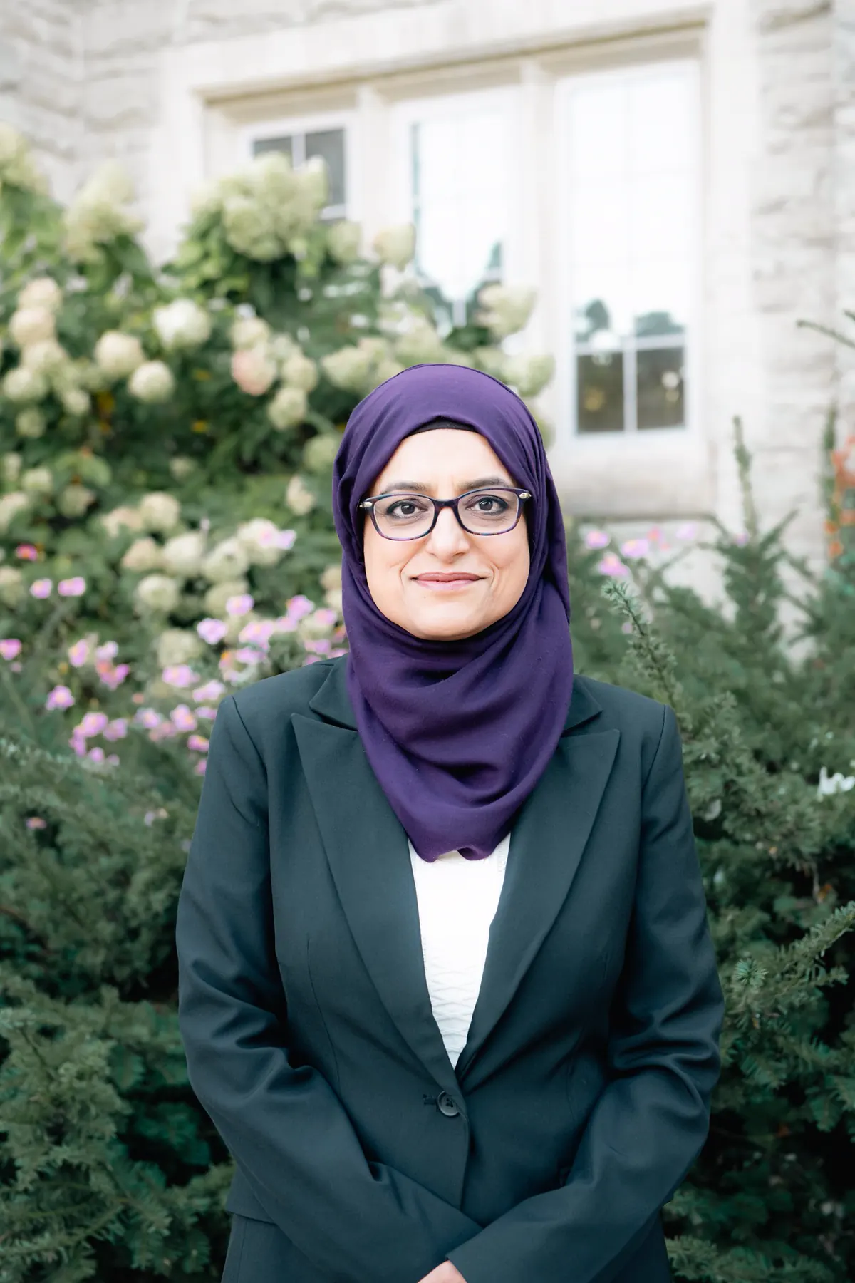 Najia Mahmud, founder of Amana Family Law, smiling in a garden